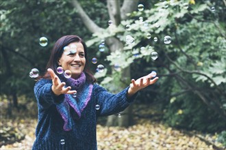 Smiling woman playing with bubbles