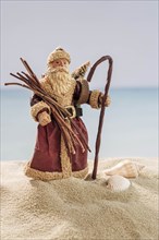 Santa ornament and shells on sand