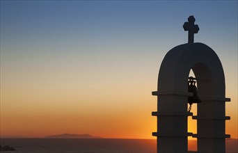 Silhouette of bell tower at sunset in Mykonos, Greece
