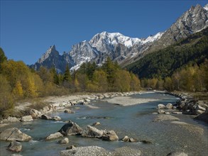Snowcapped mountain by river in Aosta Valley, Italy