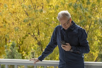 Man using phone by autumn trees