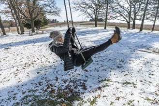 Woman on swing in snow