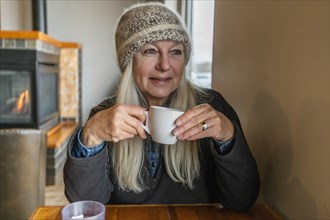 Woman wearing winter clothing holding cup
