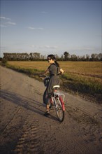 Woman riding bicycle on country road