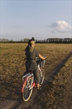 Woman riding bicycle in field