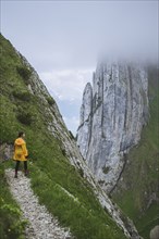 Woman wearing yellow jacket on mountain in Appenzell, Switzerland