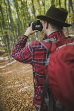 Man taking photograph in forest