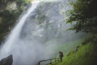 Woman on grass by waterfall