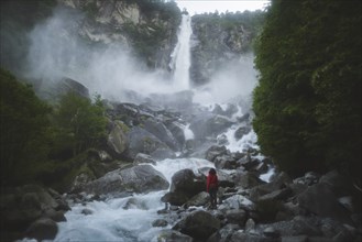 Woman on rocks by waterfall