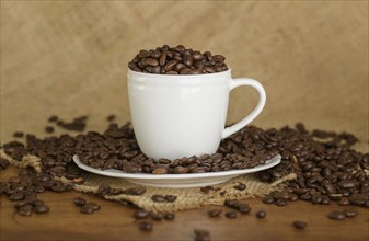 Coffee beans in cup and saucer