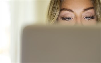 Eyes of young woman using laptop