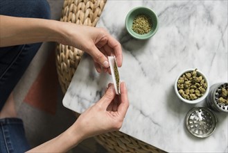 Hands of woman rolling marijuana joint