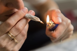 Woman lighting marijuana joint