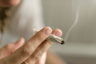 Hand of woman smoking marijuana joint