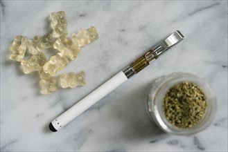 Gummi bear edibles, electronic cigarette, and marijuana in jar