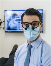 Dentist wearing surgical mask and glasses