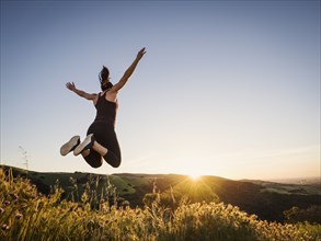 Woman jumping at sunset