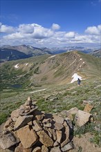Cairn and woman hiking on Berthoud Pass Trail in Colorado