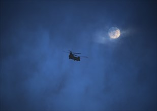 Military helicopter in night sky
