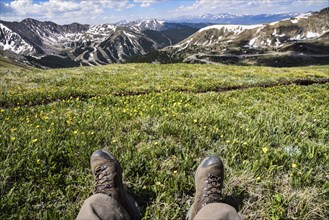 Boots of man sitting in field on mountain at Loveland Pass, Colorado