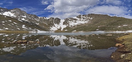 Snow on mountains by lake at Mount Evans Scenic Byway, Colorado