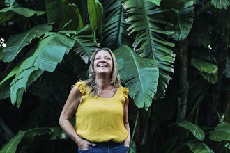Smiling woman by leaves of palm tree