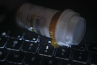 Pill bottle on computer keyboard