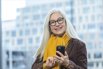 Smiling businesswoman with smartphone in office