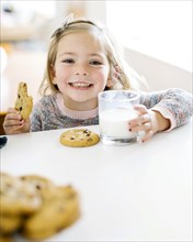 Girl eating milk and cookies