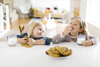 Girls eating milk and cookies