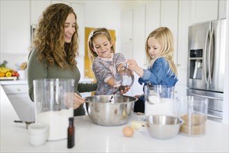Woman baking cookies with her daughters