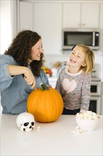 Mother and daughter carving pumpkin for Halloween