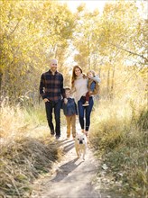 Family with pet dog on forest path
