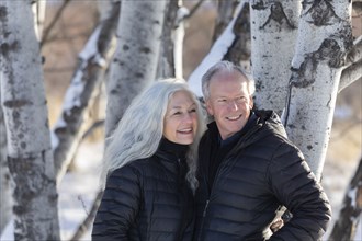 Smiling senior couple by tree