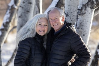 Smiling senior couple by tree