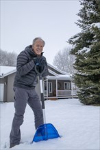 Senior man shoveling snow