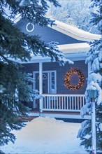 Illuminated Christmas wreath on house during winter