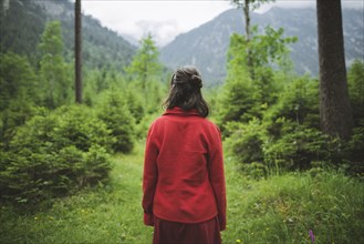 young woman with red jacket in forest