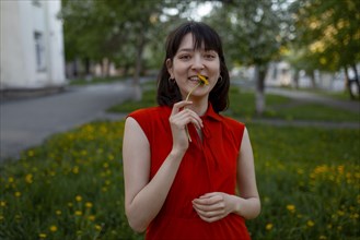 Smiling young woman holding flower