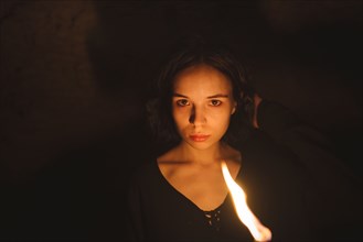 young woman with flaming torch at night