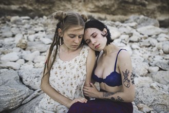 young women sitting together on beach