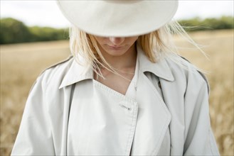young woman with fedora in wheat field
