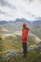 young woman in red jacket on mountain