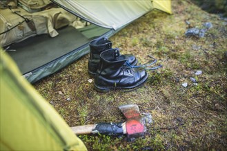 Boots and hatchet by tent