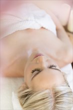 Woman relaxing lying on back on massage table