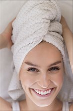 Portrait of smiling woman with head wrapped in towel