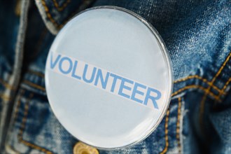 Close up of Volunteer button on denim jacket