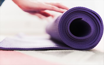 Woman's hand rolling yoga mat