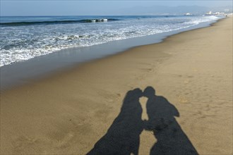 Shadow of couple kissing on Santa Monica Beach
