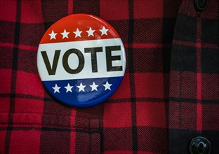 Vote button on red checked shirt